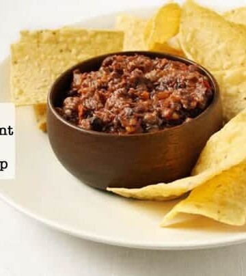 2 Ingredient Black Bean Dip in a wood bowl on a platter surrounded by tortilla chips.