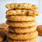 A stack of gluten-free snickerdoodles. The top cookie is broken in half.