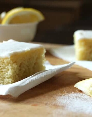 Gluten-free lemon cake squares on wood board.