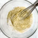 Dry ingredients for almond flour pancakes in a bowl being whisked.