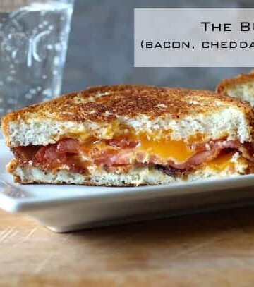 Bacon, Cheddar, Tomato Sandwich on white platter.