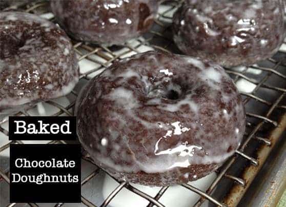 Baked gluten-free chocolate doughnuts on wire rack.