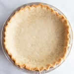 Empty baked gluten-free pie crust cooling in a pan.