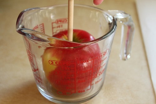 Apple in empty glass measuring cup.