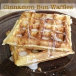 Gluten-Free cinnamon bun waffles on plate with glaze.