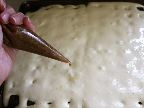 Gluten-Free Cinnamon Bun Waffle batter in pan. Cinnamon topping in pastry bag.