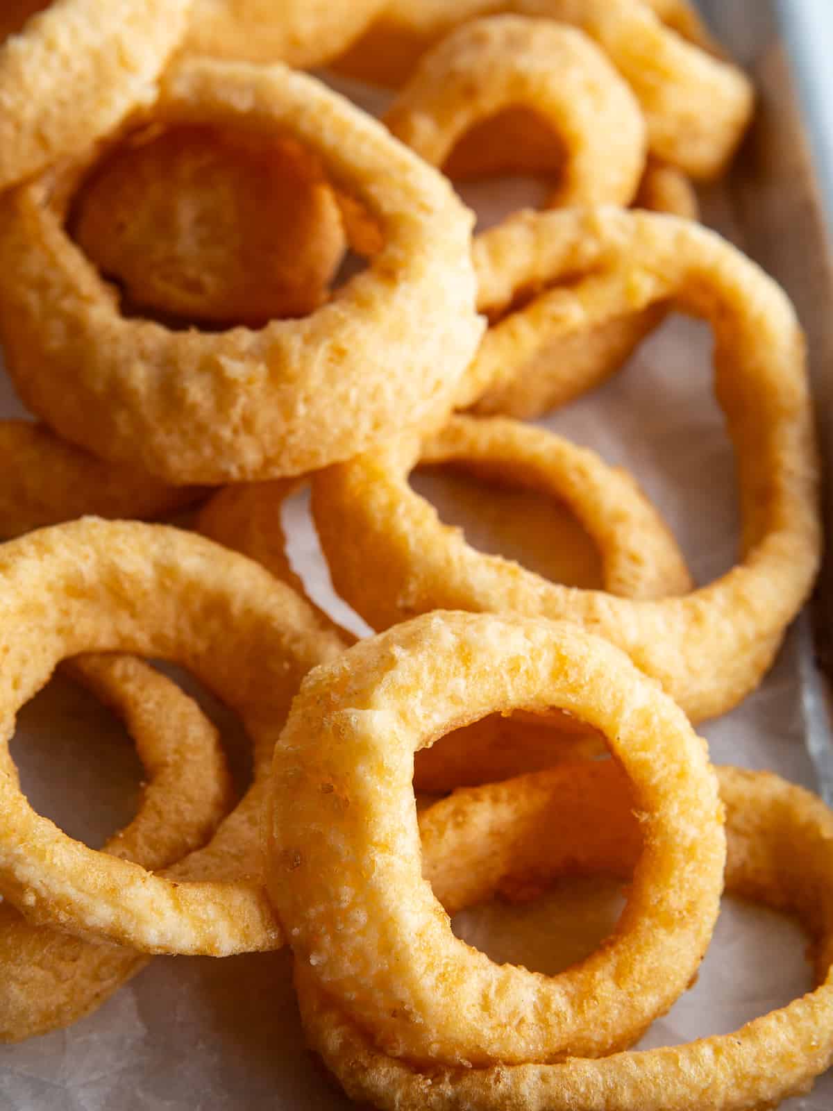 Fried gluten-free onion rings on a baking sheet.