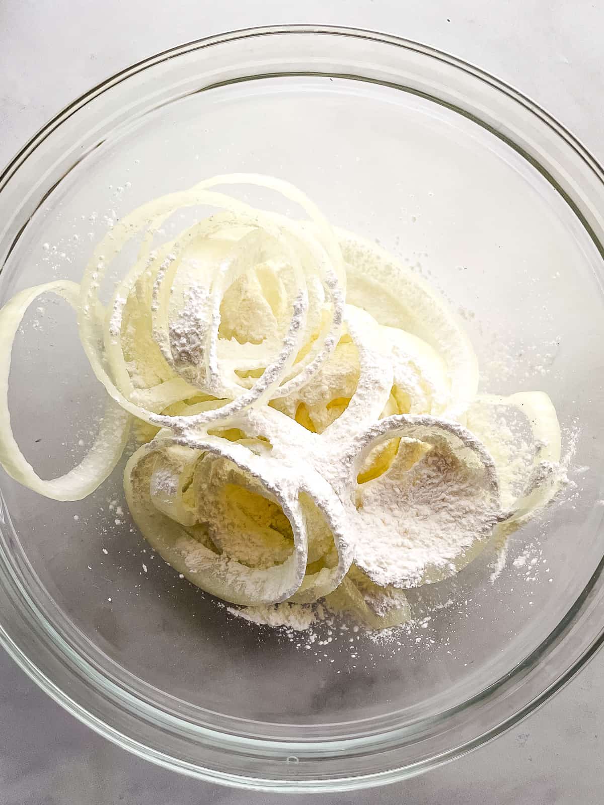 Coating onion rings in cornstarch.