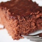 Gluten-free cola cake on white plate with fork.