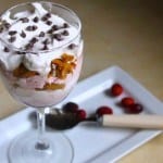 Thanksgiving Cranberry Trifle in a wine glass. Topped with whipped cream and chocolate chips.