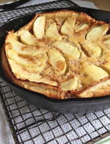 Gluten-Free Dutch Apple Pancake in a skillet set on a cooling rack.