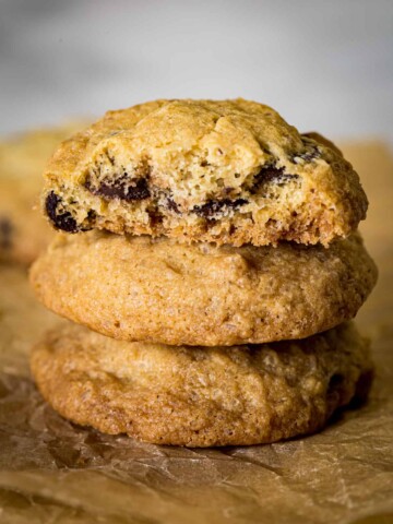 Stack of gluten-free chocolate chip cookies. Top cookie is broken in half to show texture.