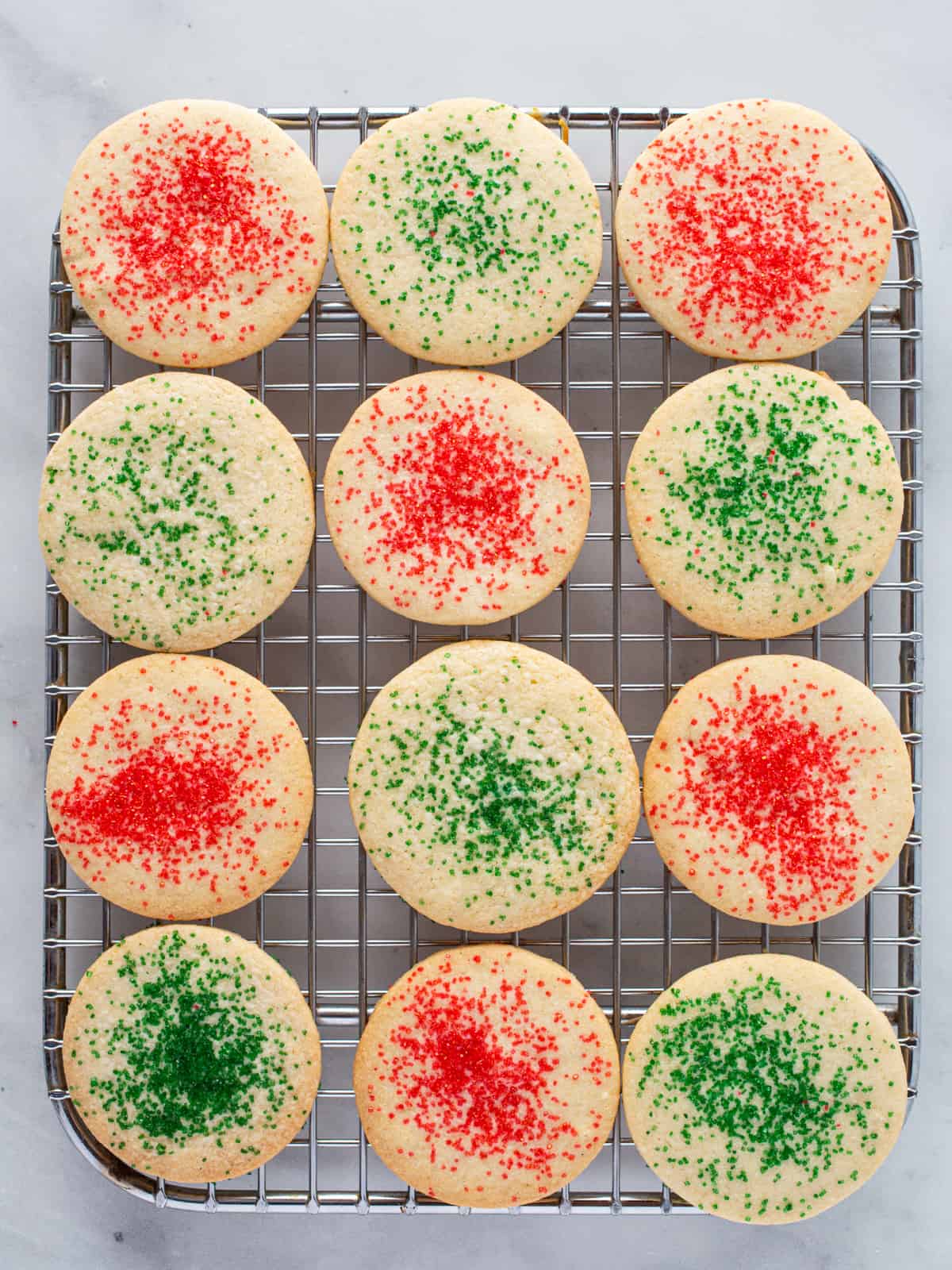 Gluten-free sugar cookies on a wire rack with red and green sugar.