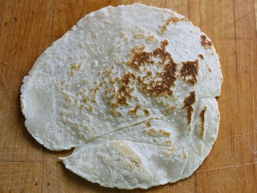 Gluten-free flour tortilla with brown spots.