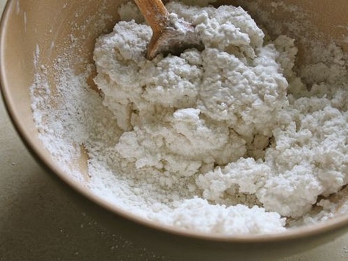 Mixing gluten-free flour tortilla dough. The dough is wet and is starting to hold together.