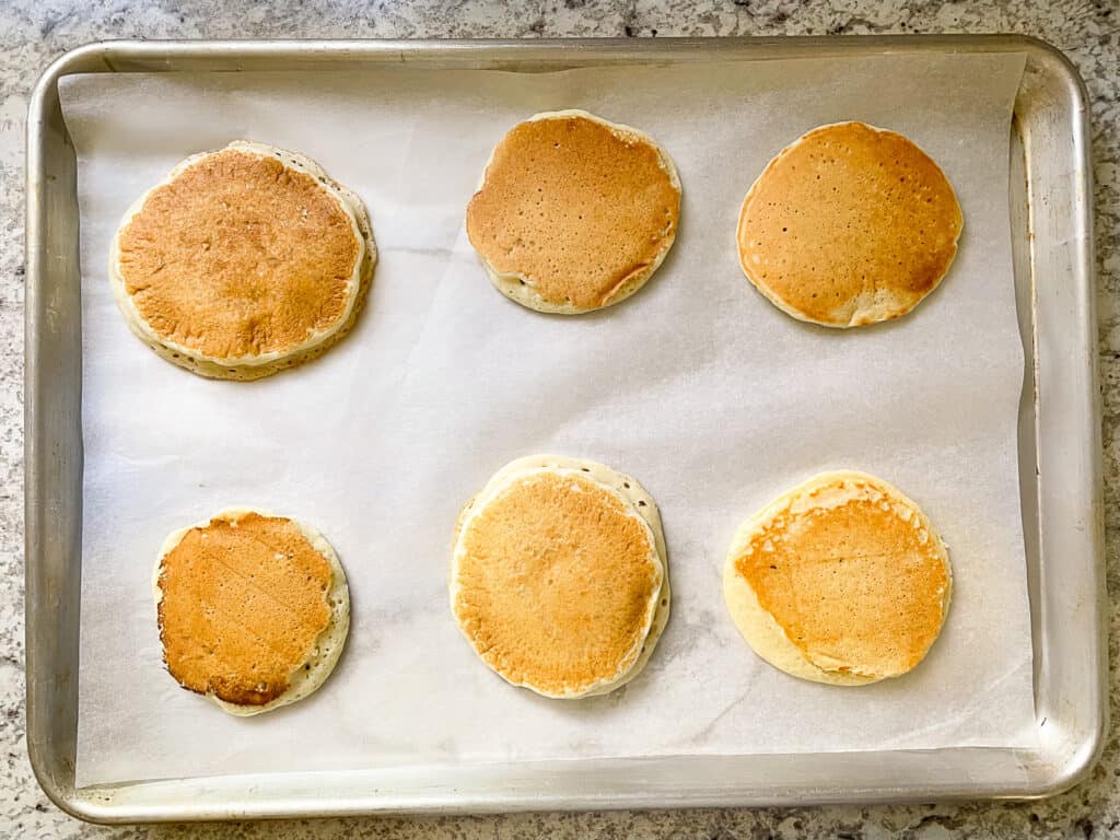 Frozen gluten-free pancakes on a baking sheet.