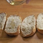 Drizzling olive oil on gluten-free bread for garlic bread.