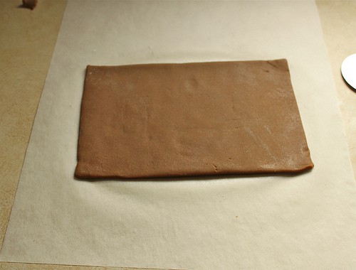 Rectangle of gluten-free gingerbread cookie dough on parchment paper.