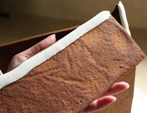 Gluten-free gingerbread roof with icing on the top edge.