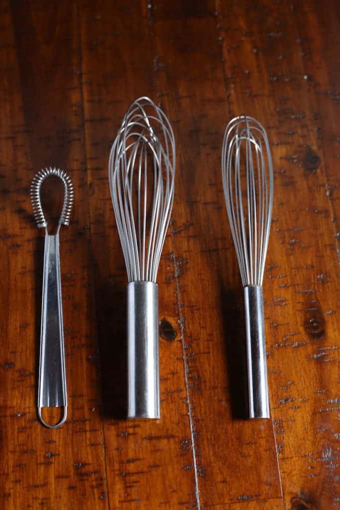 An assortment of whisks. Small egg whisk. Balloon whisk. Slim ballon whisk.