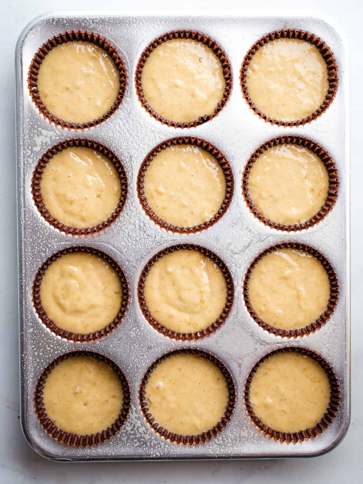 Gluten-free banana muffin batter in a muffin pan. 