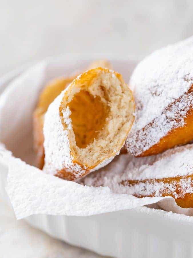 Gluten-Free Beignet Cut in Half. Tossed in Powdered Sugar