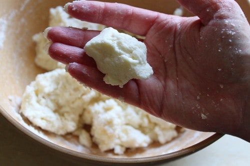 Gluten-free cobbler dough ball on the palm of a hand.