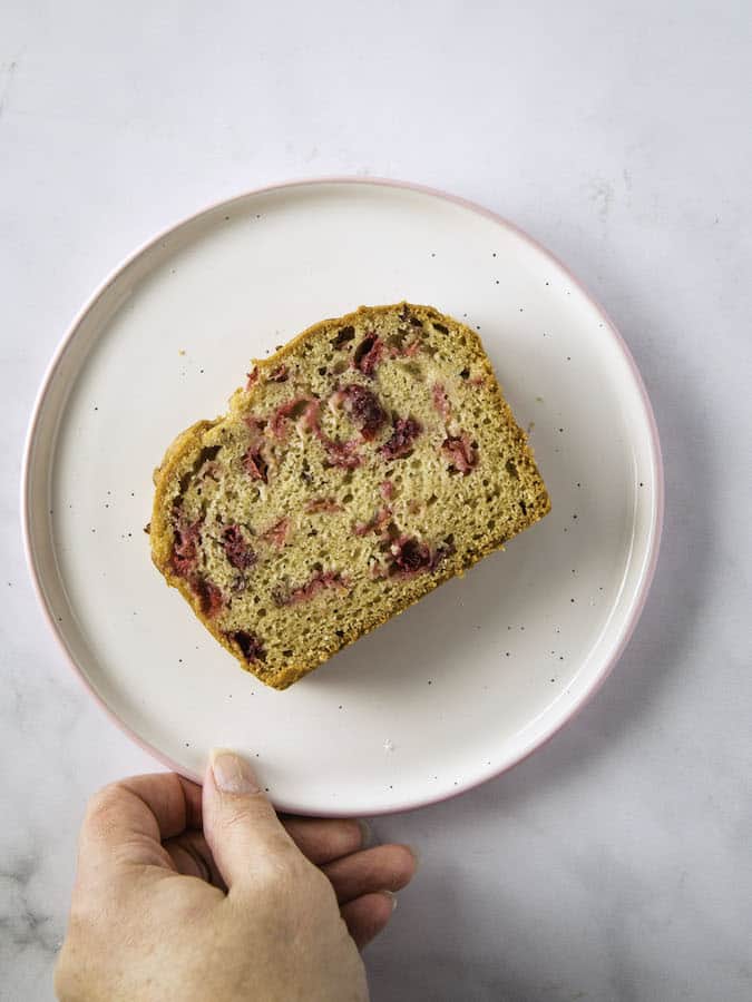 Slice of gluten-free cranberry bread on a plate.