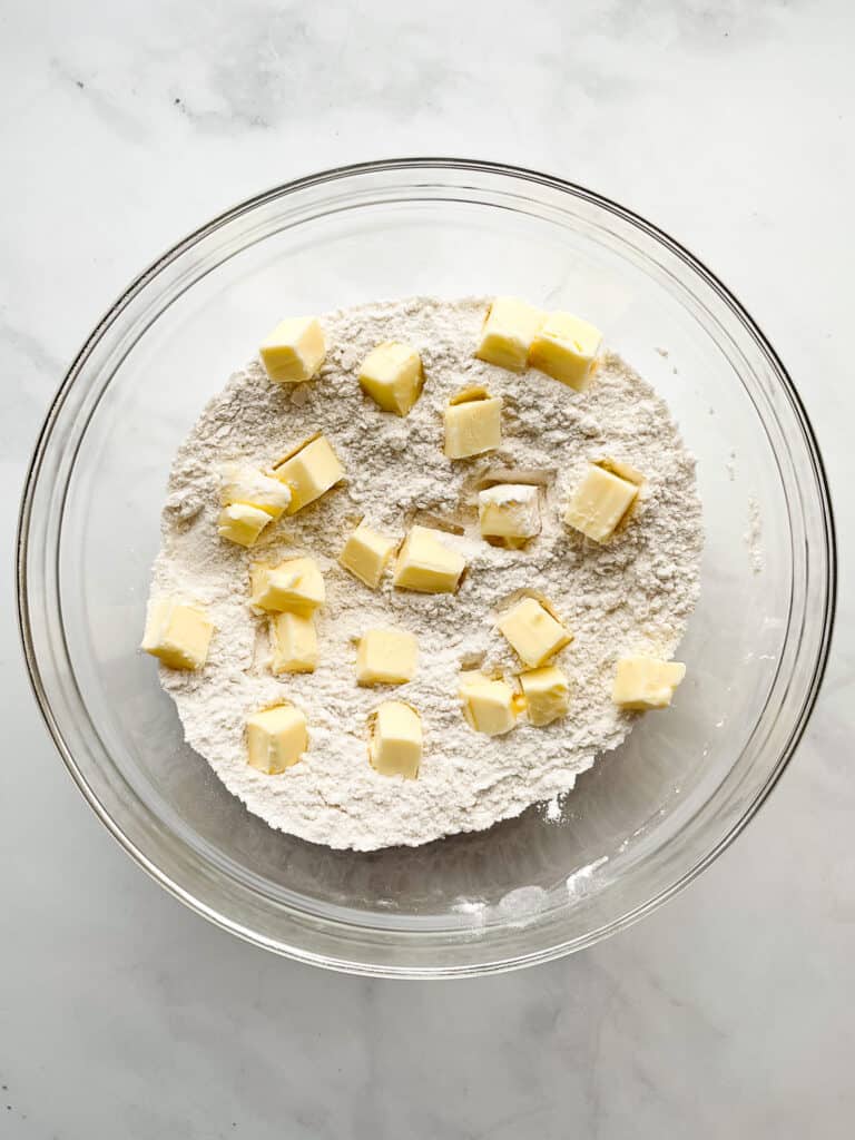 Gluten-free flour with small piece of butter in a glass bowl.