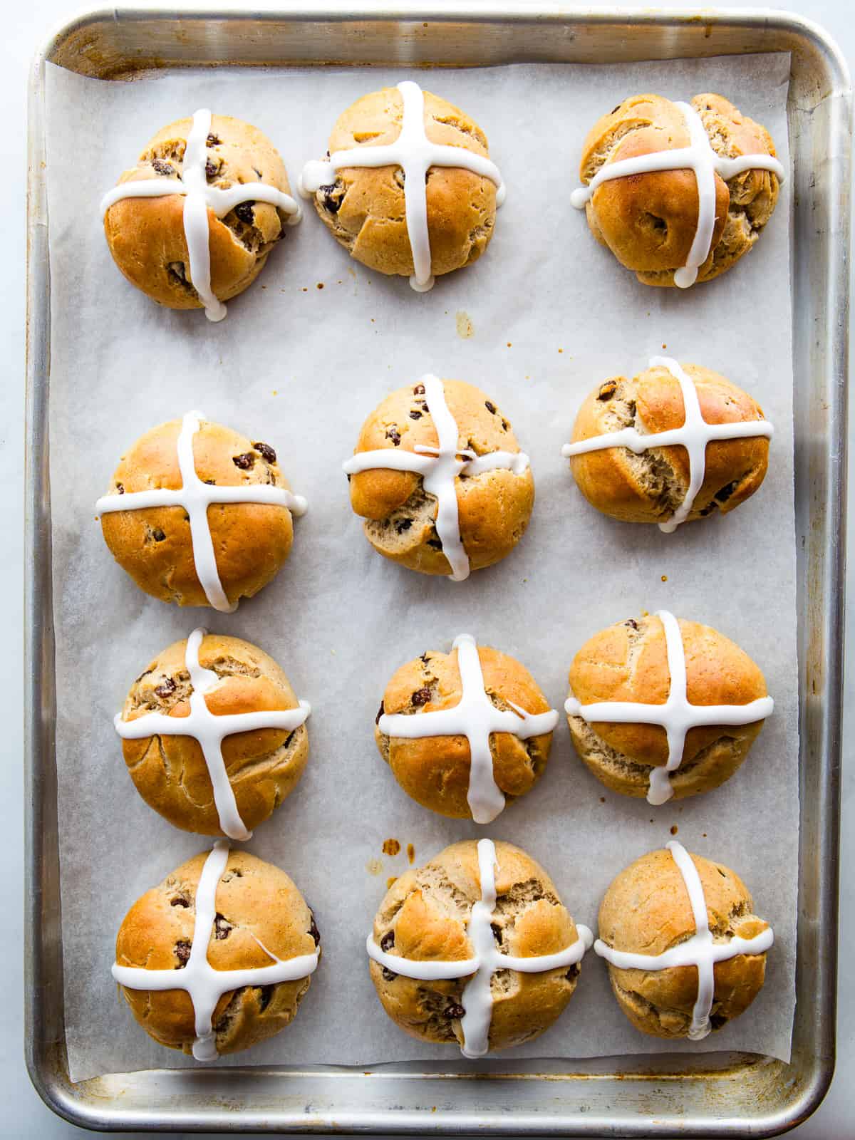 Gluten-free hot cross buns on a sheet pan.