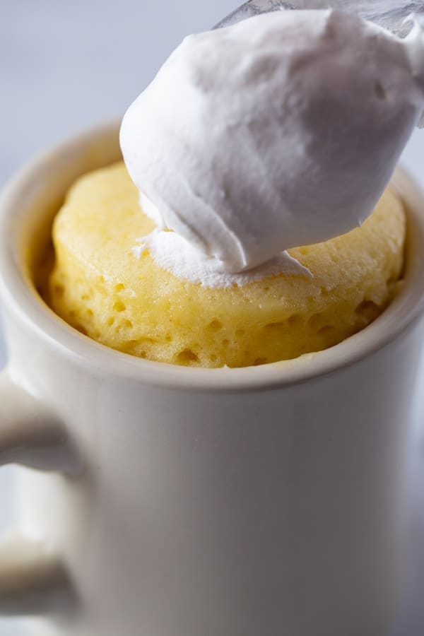 Gluten-Free Mug Cake in White Mug. Topped with Whipped Cream 