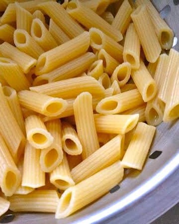 Cooked gluten-free pasta in a strainer.