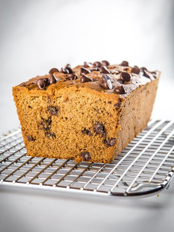 Baked gluten-free banana bread with chocolate chips on a cooling rack.