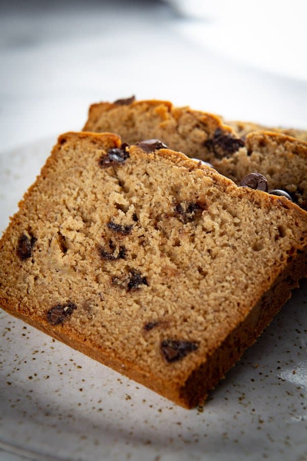 Sliced gluten-free peanut butter banana bread on plate.