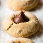 A gluten-free peanut butter blossom sits on a piece of parchment paper.