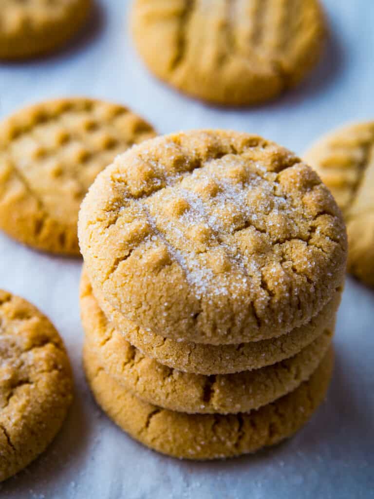 Gluten-free peanut butter cookies in a stack on a baking sheet.