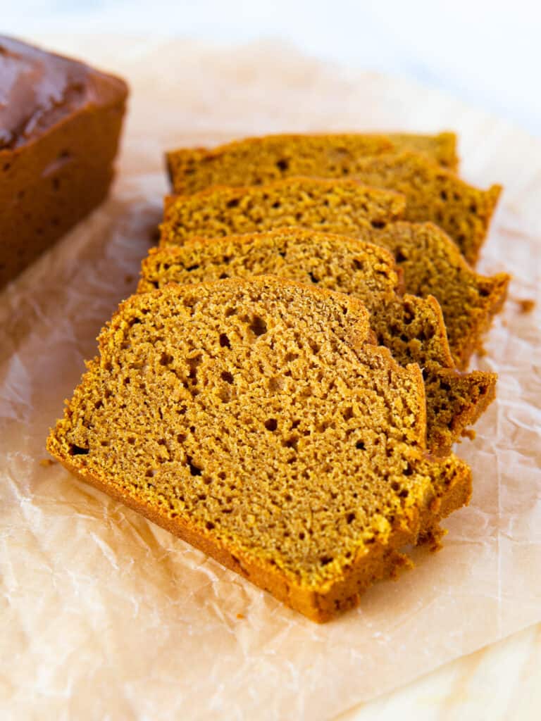 Sliced gluten-free pumpkin bread on a cutting board.