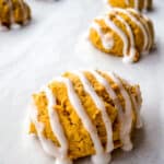 Gluten-free pumpkin cookies baked and iced on a baking sheet.