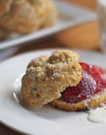 Gluten-Free Shortcake, split and topped with strawberries and a drizzle of cream.