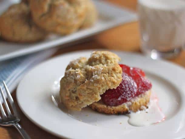 Gluten-Free Shortcake, split and topped with strawberries and a drizzle of cream.