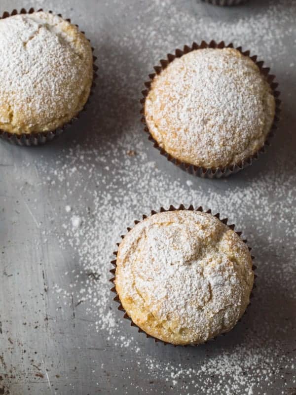 Gluten-free sour cream muffins topped with powdered sugar.