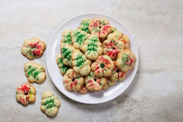 Gluten-free spritz cookies on white plate.