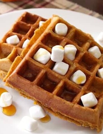 Sweet Potato Casserole Waffles with mini marshmallows and syrup on a plate.