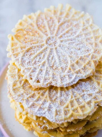 Stack of Baked Pizzelles Dusted with Powdered Sugar