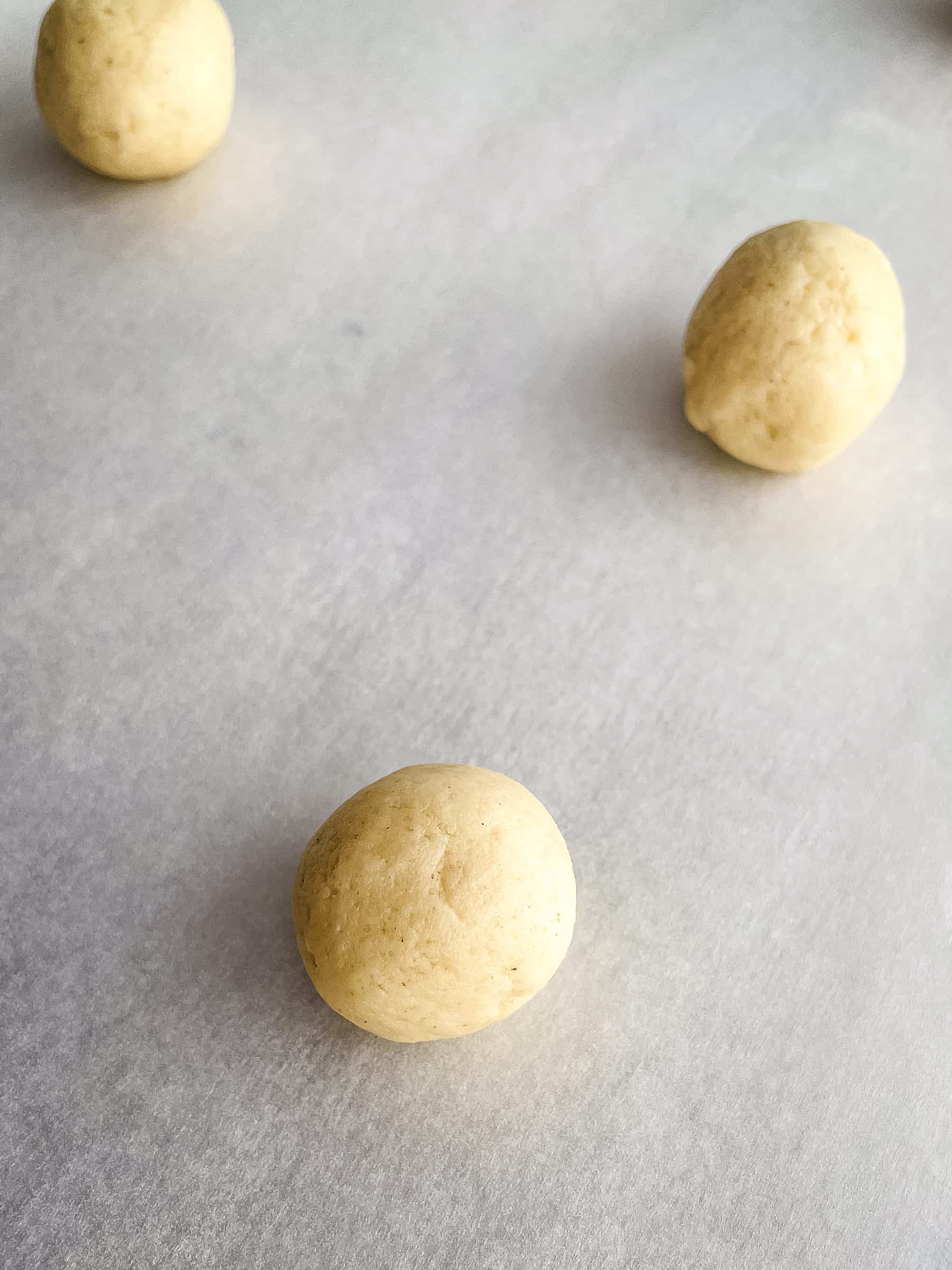 Gluten-free thumbprint cookie dough on a baking sheet.