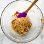 Gluten-free zucchini bread batter right after mixing. Very thick with a purple spatula in the bowl.