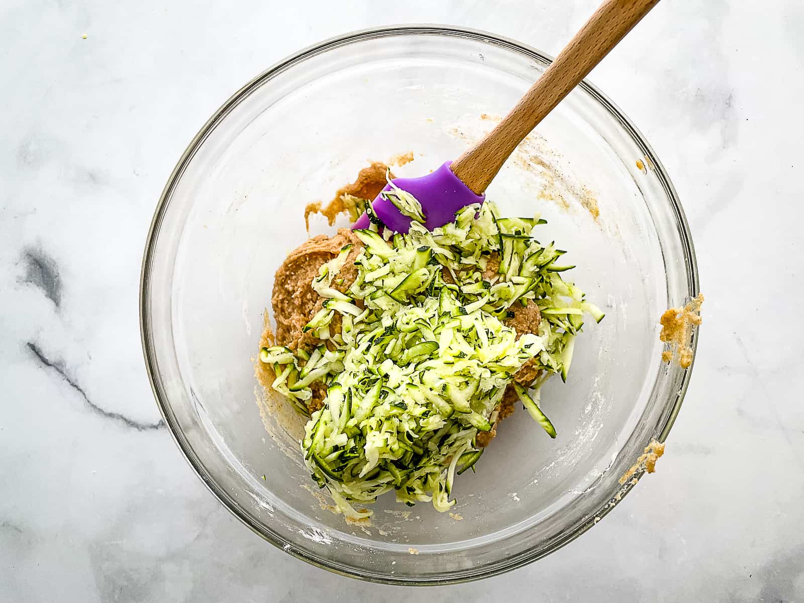 Grated zucchini about to be stirred into gluten-free zucchini bread batter.