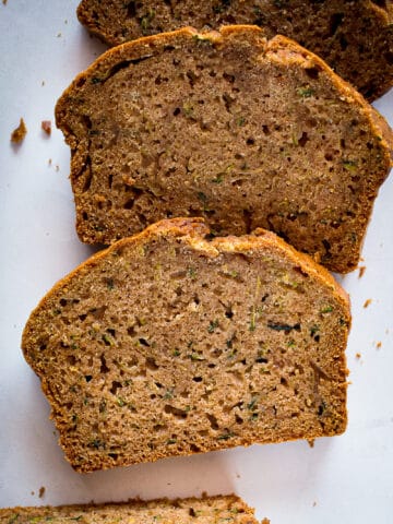 Slices of gluten-free zucchini bread on a board.