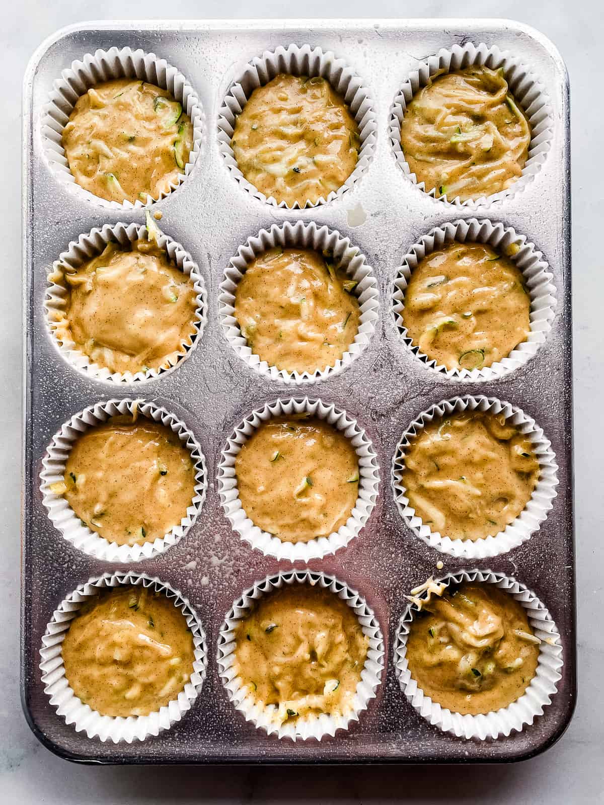 Gluten-free zucchini muffin batter in pan.