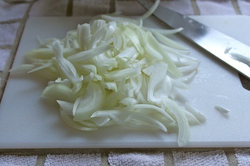 Chopped onions on cutting board.